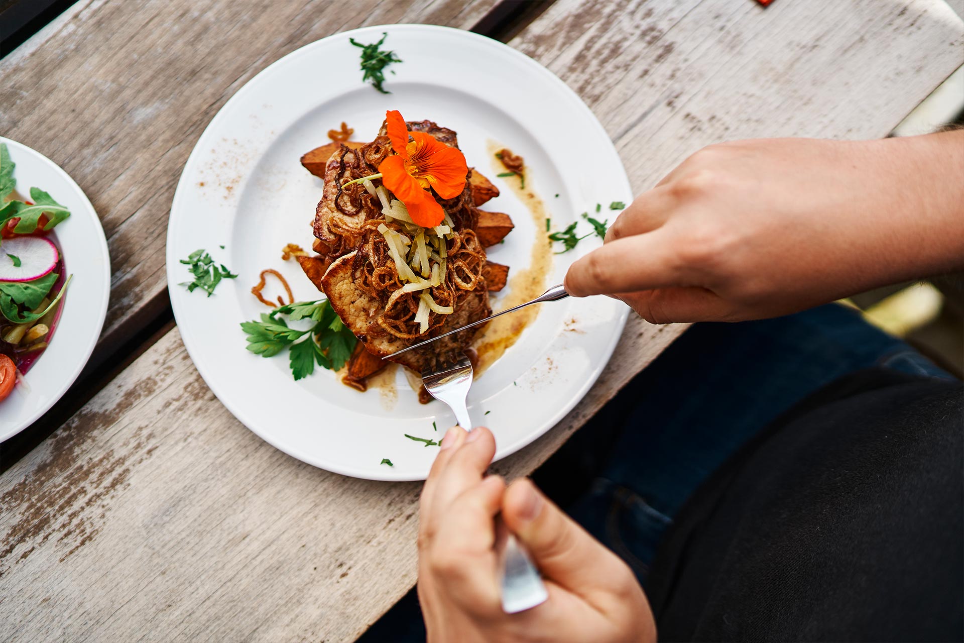 Gast schneidet gerade einen phänomenalen Zwiebelrostbraten