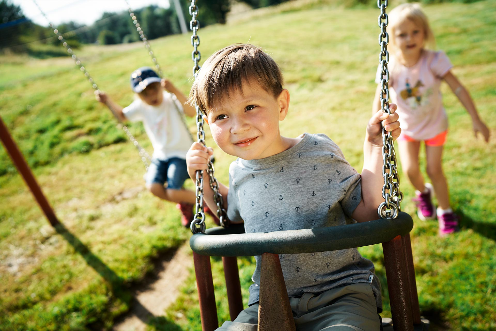 Kinder beim Schaukeln an einem Spielplatz im Bayerischen Wald