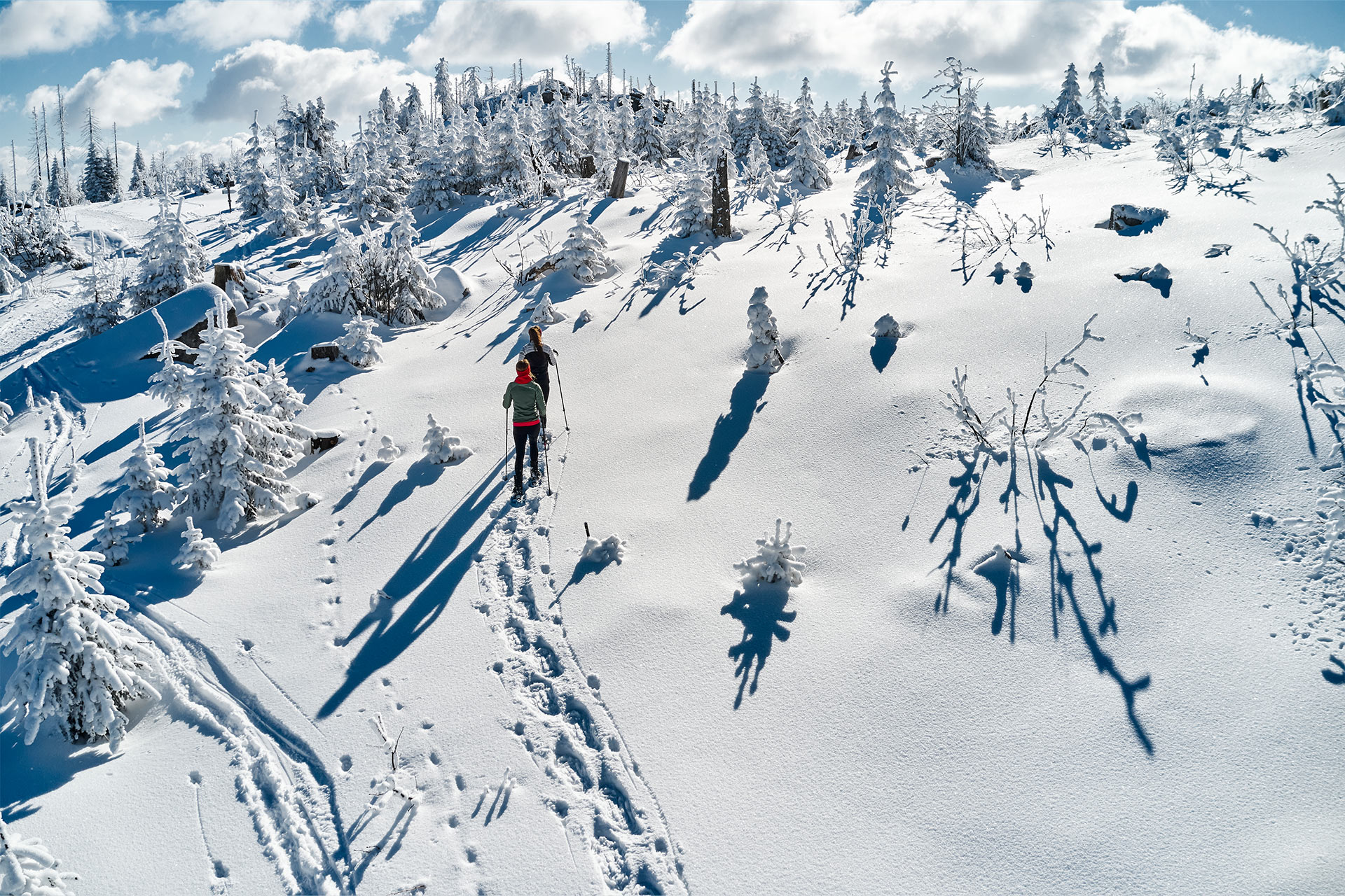Fußstapfen im tiefen Schnee von zwei Frauen die eine Winterwanderung machen